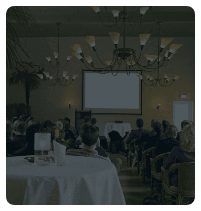 Audience attending a presentation in a conference room.