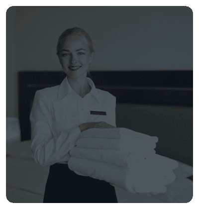 Housekeeper holding folded towels in a hotel room.