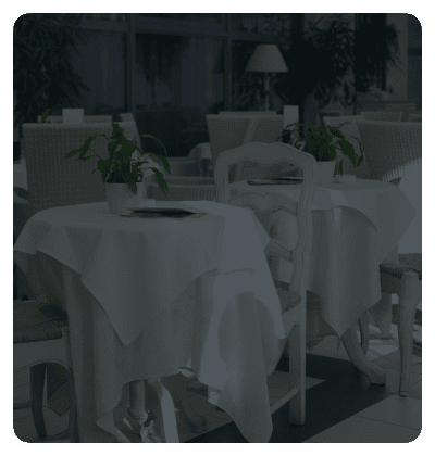 Elegant restaurant with white tablecloths and potted plants